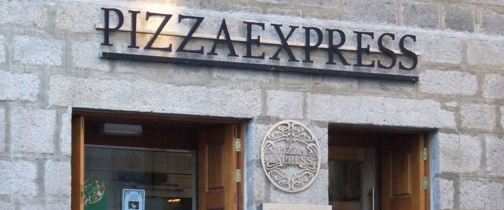 "Pizza Express storefront with sign and logo on stone building facade"